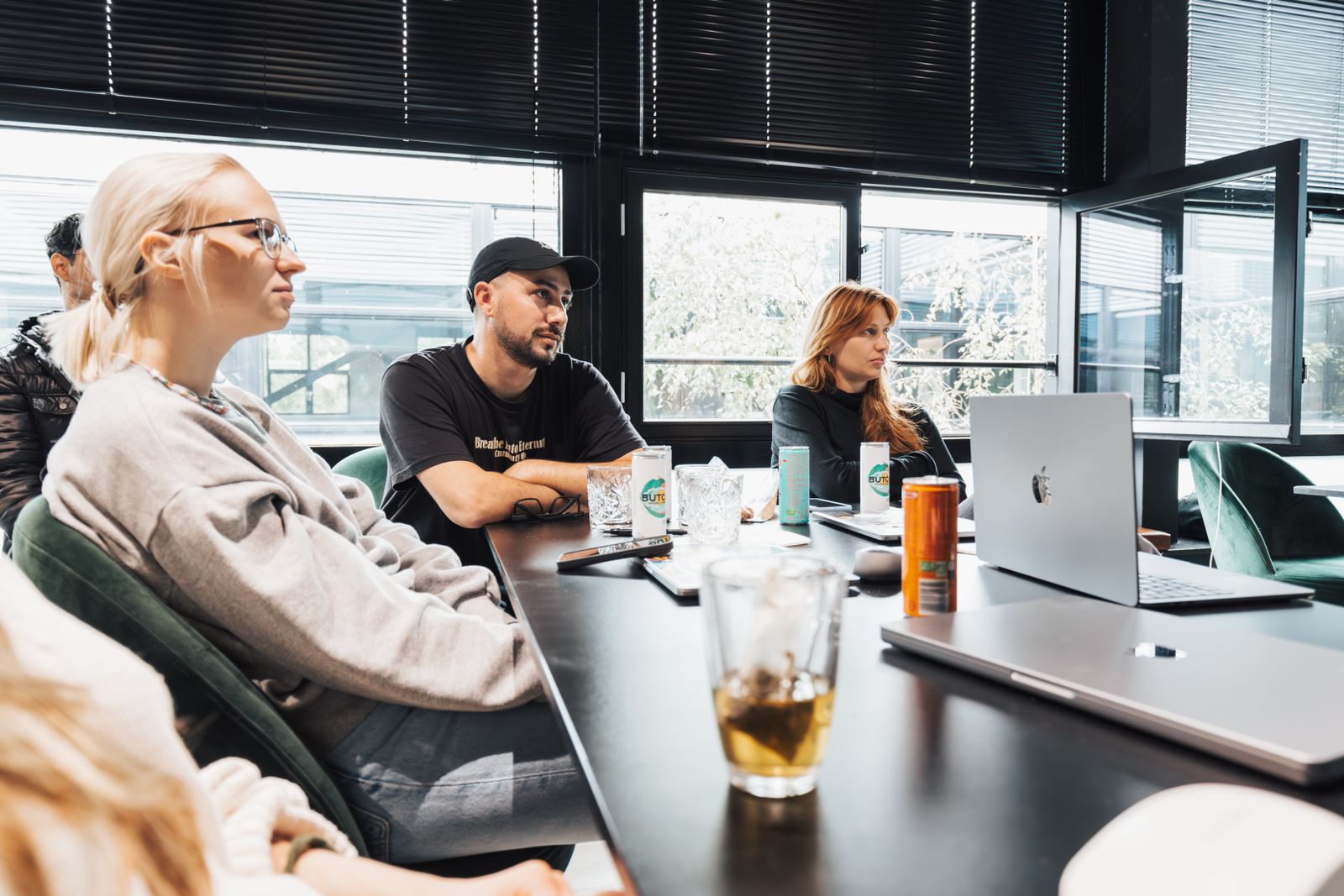Three colleagues sitting around a meeting table, quietly listening to each other.