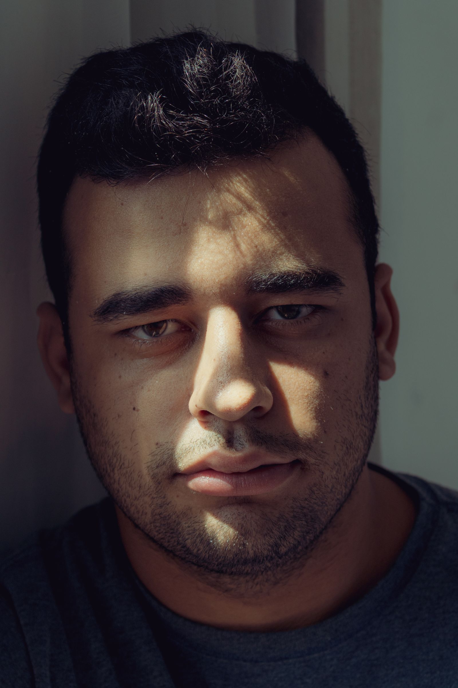 A thoughtful adult in a quiet moment, natural window light across the face.