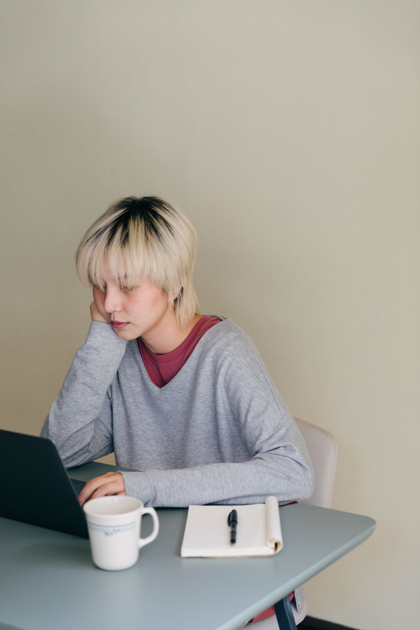 Adult thoughtfully typing a private message at a laptop