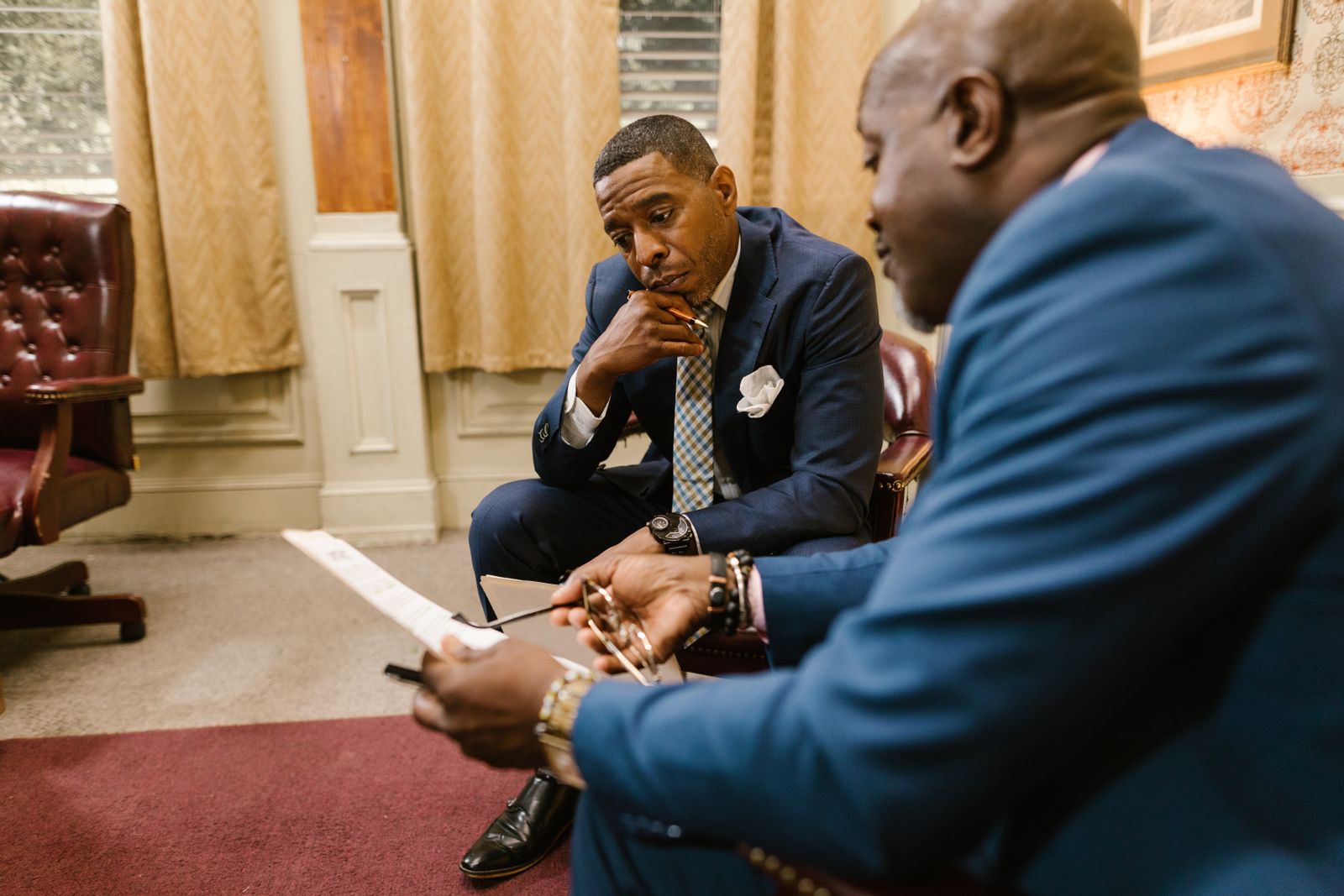 Two adults in professional attire in a quiet, attentive one-on-one conversation, one listening thoughtfully.